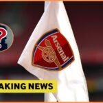 Arsenal logo on corner flag, and breaking news banner